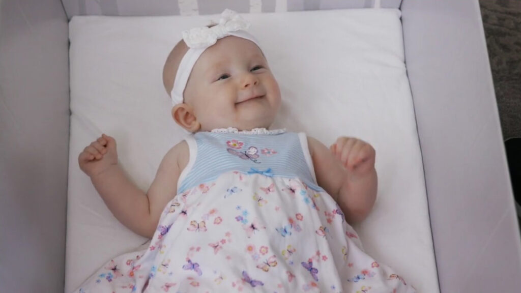 Smiling baby in safe sleep baby box featured in healthcare video production