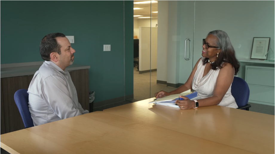 Thumbnail of a FMLA video for patients showing an employee and HR representative at an office table