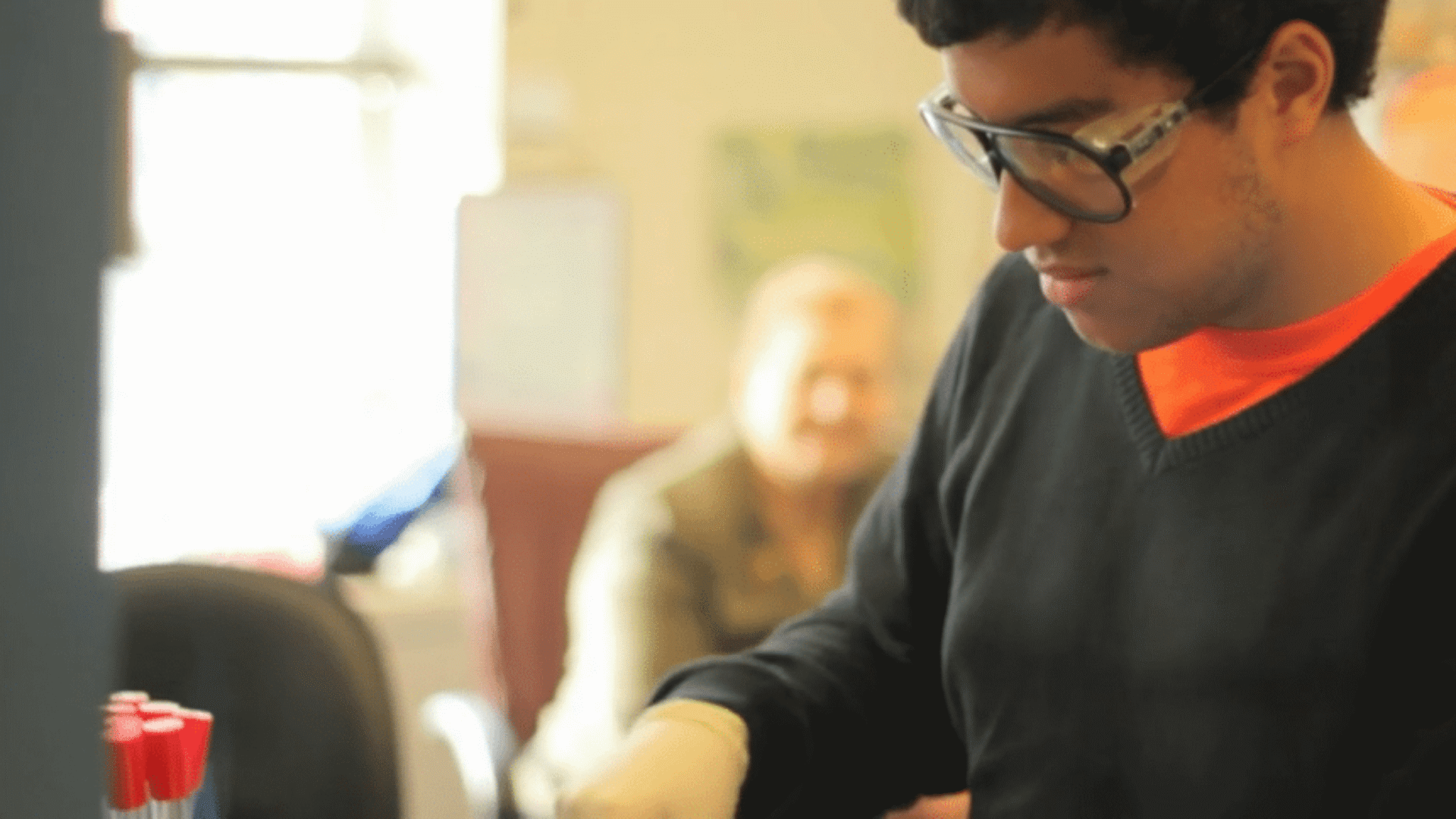 Student conducting chemistry experiment featured in educational video production