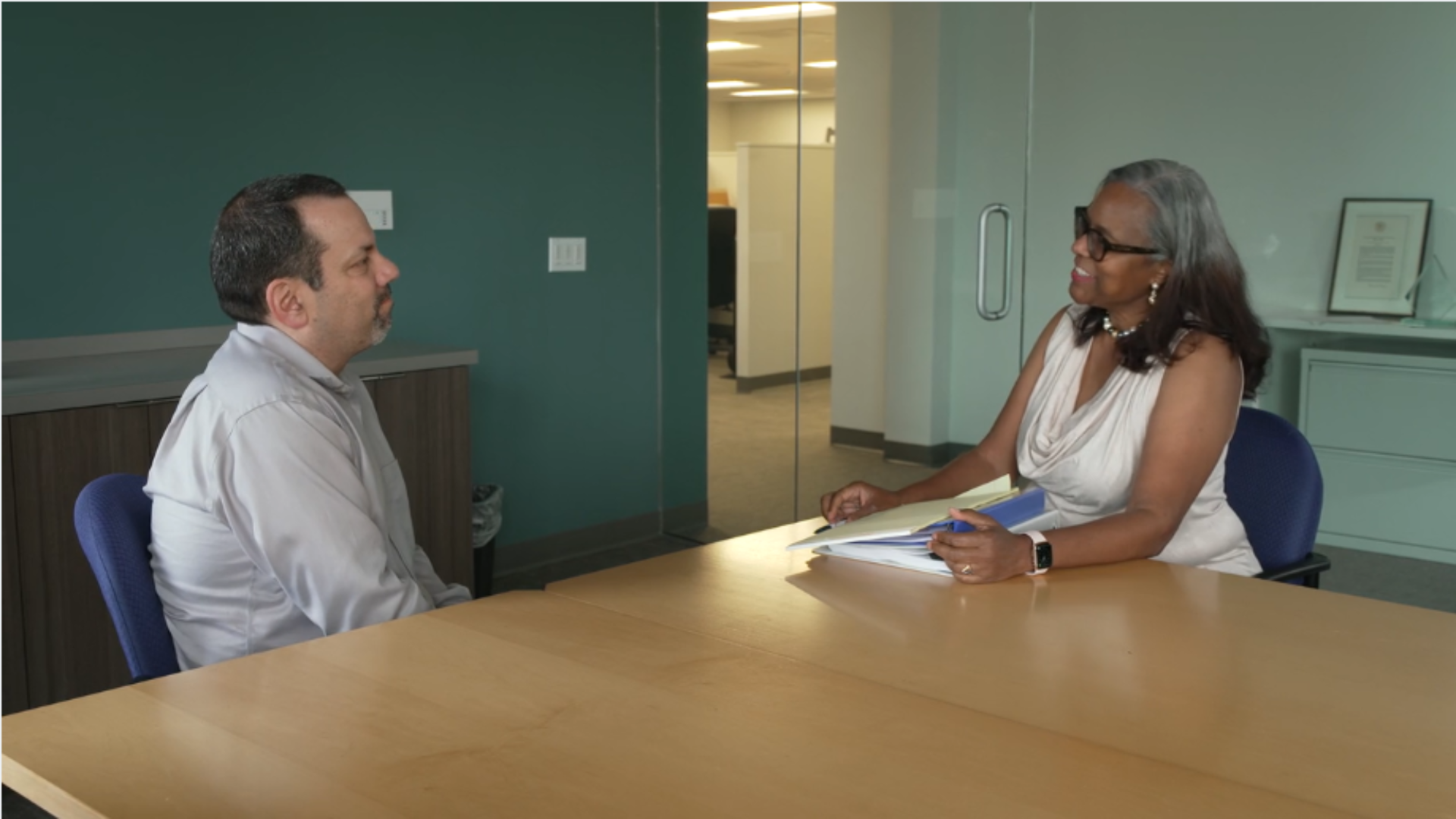 Thumbnail of a FMLA video for patients showing an employee and HR representative at an office table